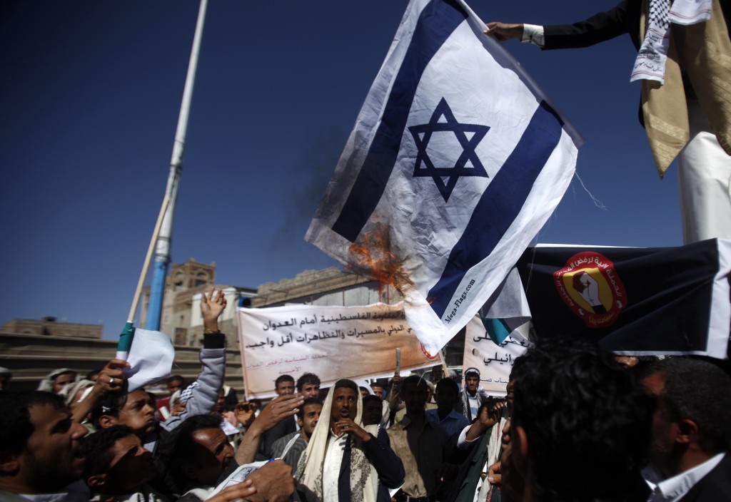 Pro-Palestinian protesters burn Israeli flag during a demonstration against Israel's military operation in the Gaza Strip in Sanaa